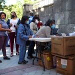Decenas de personas acuden al reparto de alimentos que la Fundación Madrina realiza en la Plaza San Amaro en Madrid el pasado junio