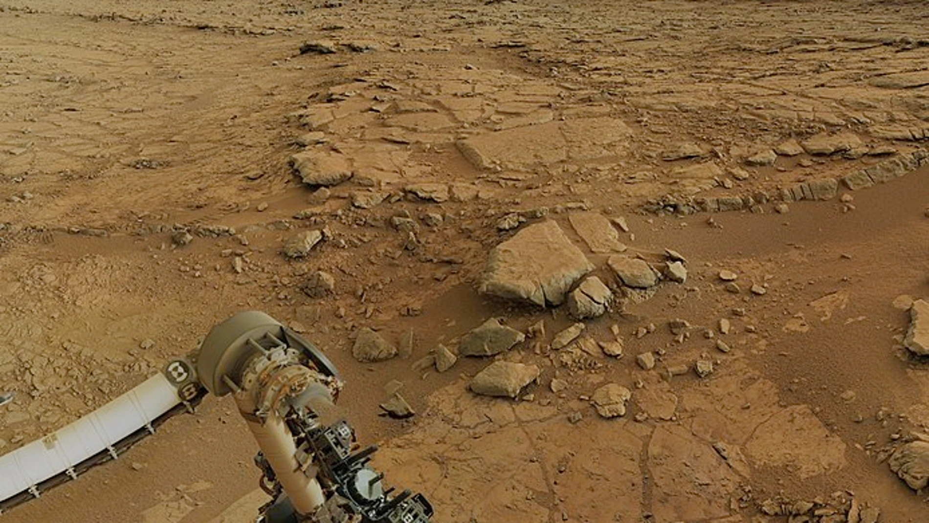 El brazo robótico de la sonda Curiosity, con su taladro posicionado sobre la roca.