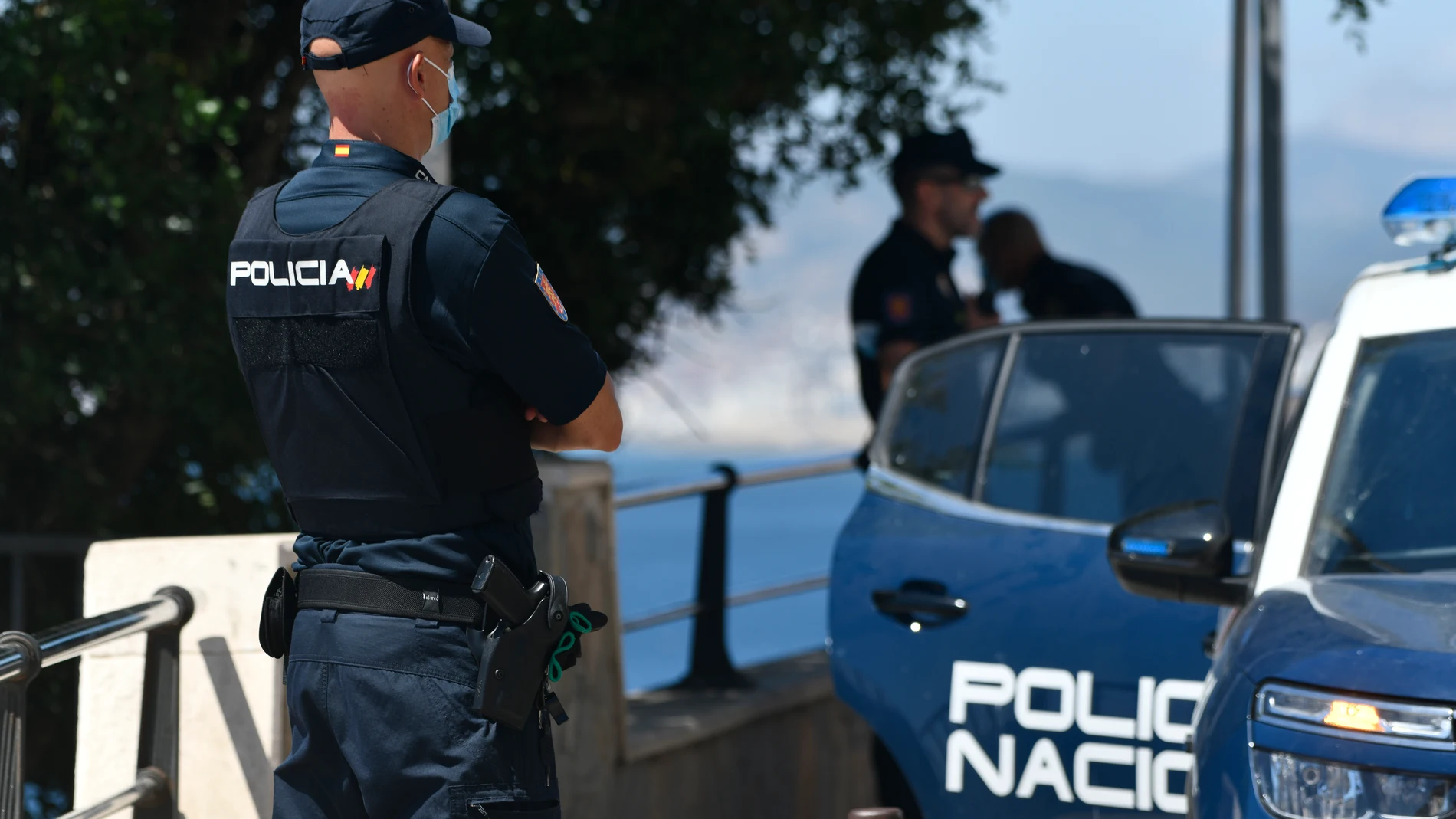 Un agente de policía nacional vigila en una zona rocosa de la playa, en una imagen de archivo
