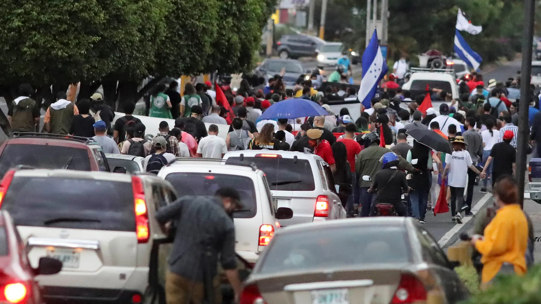AME8974. TEGUCIGALPA (HONDURAS), 28/06/2021.- Grupos de personas participan en una marcha en conmemoración del golpe de estado en Honduras en el año de 2009 hoy, en Tegucgalpa (Honduras). El partido Libertad y Refundación (Libre, izquierda) conmemoró este martes el 12 aniversario del golpe de Estado del 28 de junio de 2019 al entonces presidente de Honduras, Manuel Zelaya, con una protesta contra las Zonas de Empleo y Desarrollo (ZEDE) que impulsa el oficialismo. EFE/ Gustavo Amador