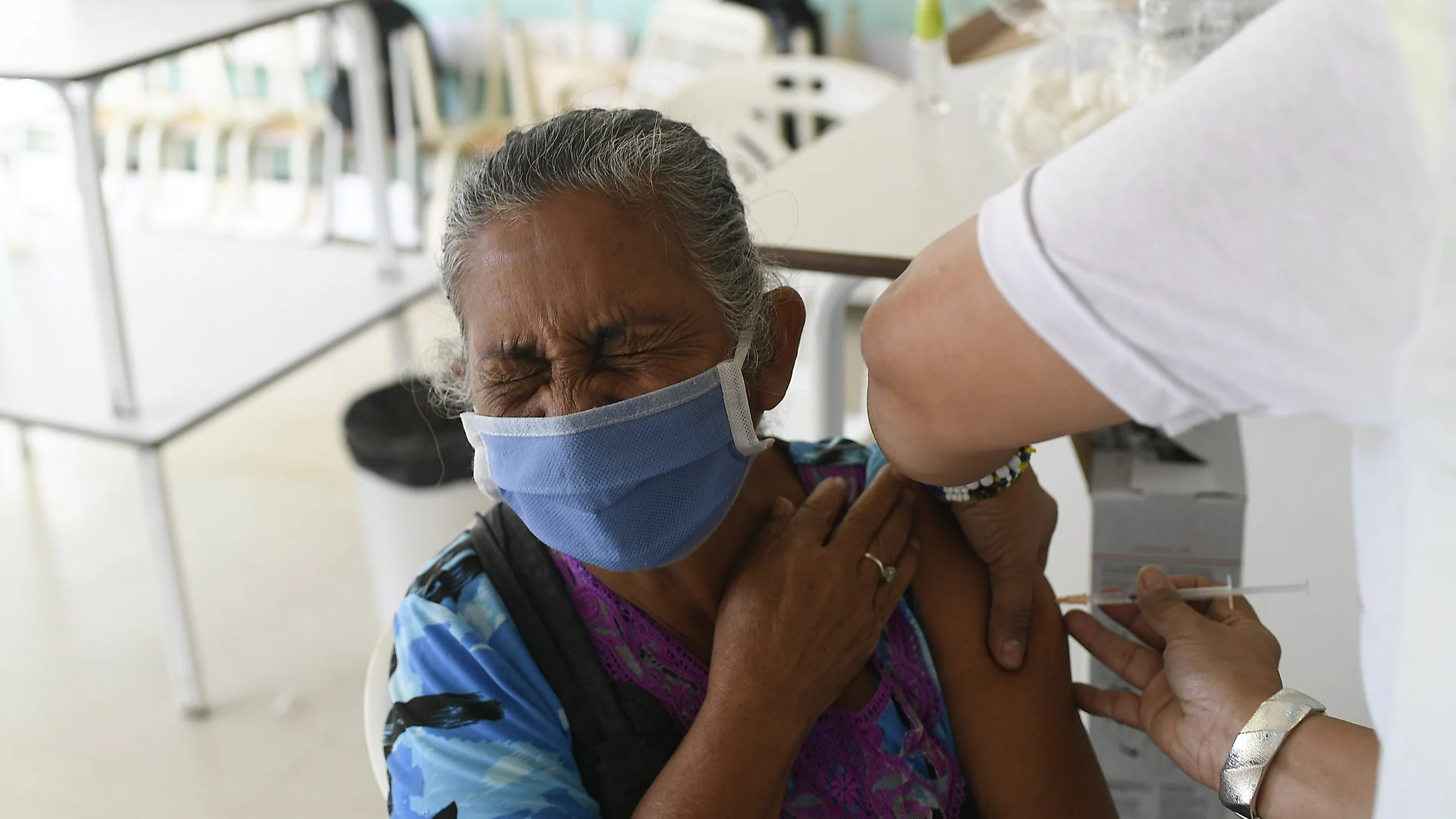 A woman closes her eyes as she gets a shot of the Cuban Abdala vaccine for COVID-19 in the Ciudad Tiuna neighborhood of Caracas, Venezuela, Tuesday, June 29, 2021. (AP Photo/Matias Delacroix)