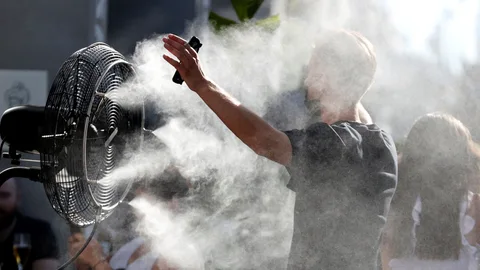 Un hombre se refresca con los ventiladores de una terraza en Madrid