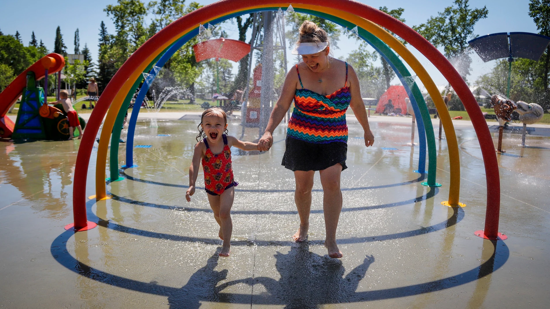 Poppy Collins (en la izquierda), de cinco años, y su madre Crystal Collins tratan de refrescarse para superar la ola de calor extremo en Vancouver