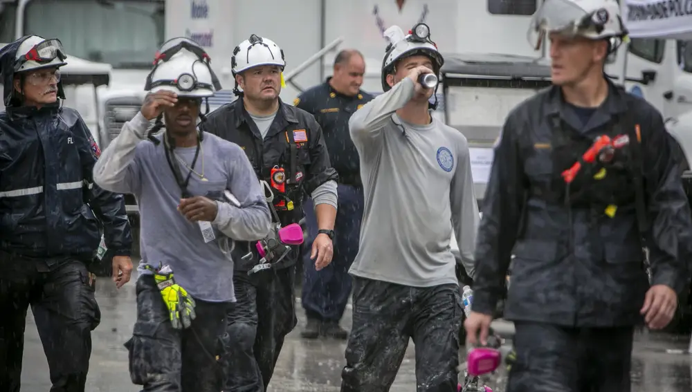 Los miembros de un equipo de búsqueda y rescate salen del sitio del colapso del edificio después de su turno en Surfside, Florida