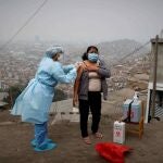 Una enfermera de la posta médica del Cerro El Agustino vacunando contra la gripe y la neumonía a una residente, el 30 de Julio de 2020 en Lima (Perú) cuando todavía no estaba la vacuna del covid