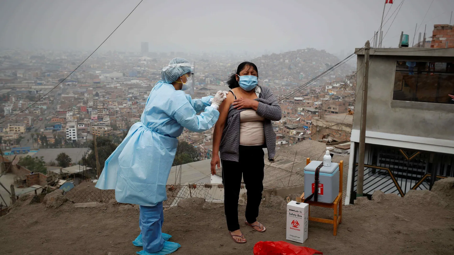Una enfermera de la posta médica del Cerro El Agustino vacunando contra la gripe y la neumonía a una residente, el 30 de Julio de 2020 en Lima (Perú) cuando todavía no estaba la vacuna del covid