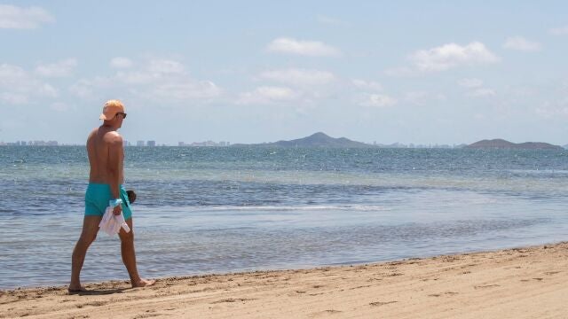 Un hombre camina en la playa del Mar Menor en Los Alcázares