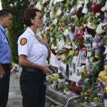 From left, Miami-Dade Fire Rescue personnel Fai Yeung and Chief Melanie C. Adams visit the makeshift memorial setup near the partially collapsed 12-story Champlain Towers South Condo in Surfside, Fla., Thursday, July 1, 2021. Search is paused because of structural concerns officials say. The apartment building partially collapsed on Thursday, June 24. (David Santiago /Miami Herald via AP)