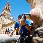 Un joven se refresca en una fuente céntrica de Córdoba debido a las altas temperaturas registradas.