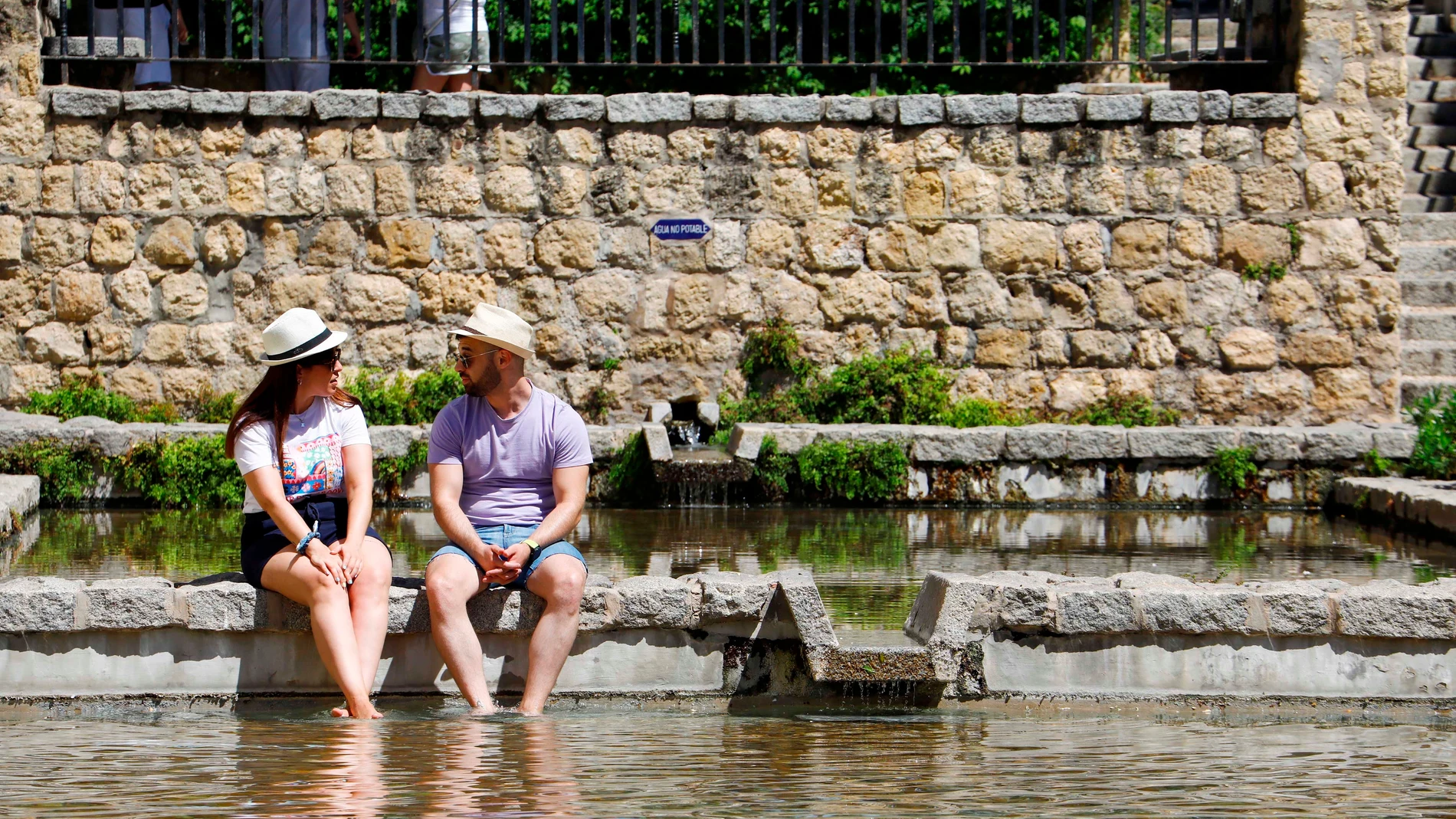 Turistas se refrescan en un estanque céntrico de Córdoba debido a las altas temperaturas registradas. EFE/Salas