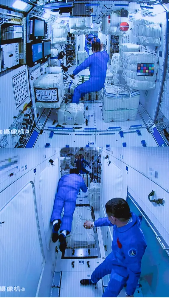 Esta imagen, captada de una pantalla del Centro de Control Aeroespacialde Beijing, la capital de China, el 17 de junio de 2021, muestra a los tres astronautas chinos que viajaron en la nave espacial Shenzhou-12 entrandoen el módulo central de la estación espacial Tianhe