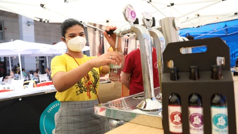 Una camarera sirve un tubo de cerveza, en las instalaciones del Leganés Beer Festival