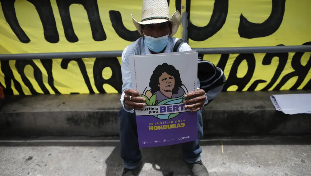 Un simpatizante de la activista asesinada, Berta Cáceres, junto a un cártel con la cara de la ambientalista asesinada, ayer