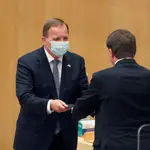 El presidente del Parlamento sueco, Andreas Norlén (dcha.), entrega a Stefan Löfven el documento que le confirma su elección como primer ministro