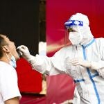In this photo released by Xinhua News Agency, a medical worker collects a swab sample for nucleic acid test in Ruili City of southwest China's Yunnan Province, on July 5, 2021. Authorities in the Chinese city bordering Myanmar locked down the city Wednesday, July 7, shutting most businesses and requiring residents to stay at home, as a fresh outbreak of COVID-19 expanded. (Wang Guansen/Xinhua via AP)