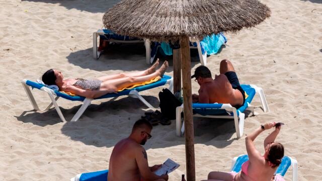 Turistas disfrutan del sol en la playa de Peguera, este jueves en el municipio mallorquín de Calvià