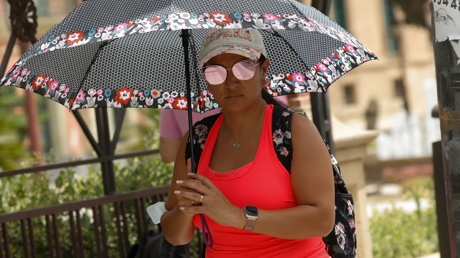 Una mujer se protege del sol con un paraguas