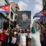 Simpatizantes del régimen cubano sostienen una fotografía del fallecido expresidente Fidel Castro durante las protestas en La Habana
