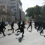 La policía corre durante las protestas en contra del gobierno cubano en La Habana