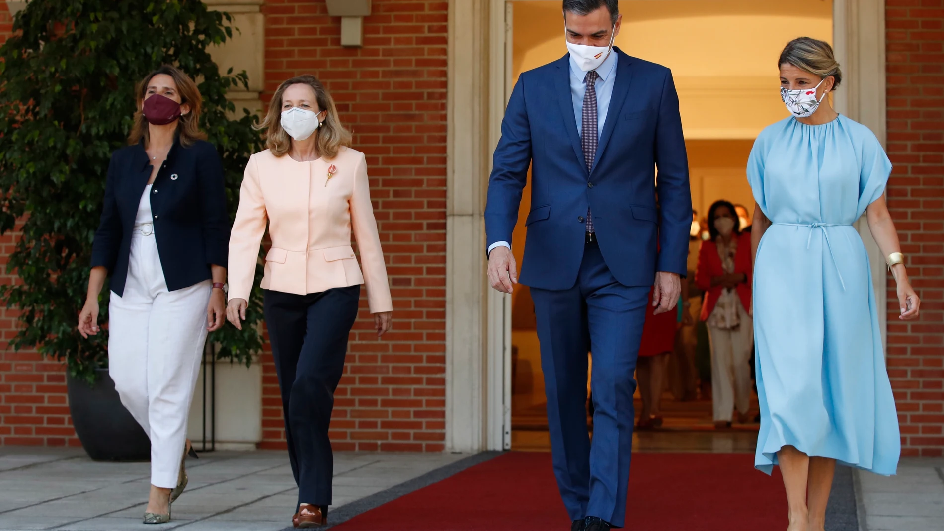 El presidente del Gobierno, Pedro Sánchez, se dirige a la escalinata acompañado por la vicepresidenta tercera y ministra para la Transición Ecológica y el Reto Demográfico, Teresa Ribera; la vicepresidenta primera y ministra de Asuntos Económicos y Transformación Digital, Nadia Calviño, y la vicepresidenta segunda y ministra de Trabajo y Economía Social, Yolanda Díaz.