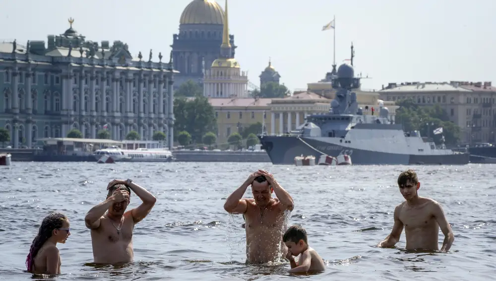 Gente bañándose en San Petersburgo cerca de un buque de guerra ruso