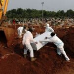 Workers wearing Personal Protective Equipments (PPE) burry the coffin of 72-year-old man who passed away due to coronavirus disease (COVID-19) at a burial area provided by the government for COVID-19 victims as the case surges, in Bekasi, on the outskirts of Jakarta, Indonesia, July 15, 2021. REUTERS/Willy Kurniawan