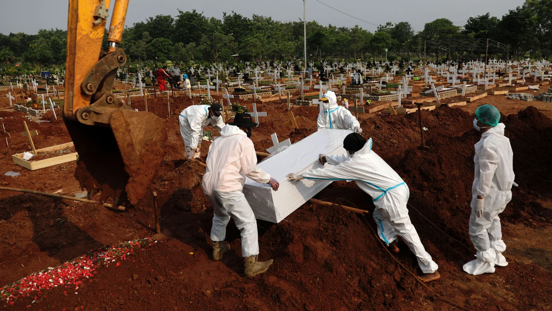 Workers wearing Personal Protective Equipments (PPE) burry the coffin of 72-year-old man who passed away due to coronavirus disease (COVID-19) at a burial area provided by the government for COVID-19 victims as the case surges, in Bekasi, on the outskirts of Jakarta, Indonesia, July 15, 2021. REUTERS/Willy Kurniawan
