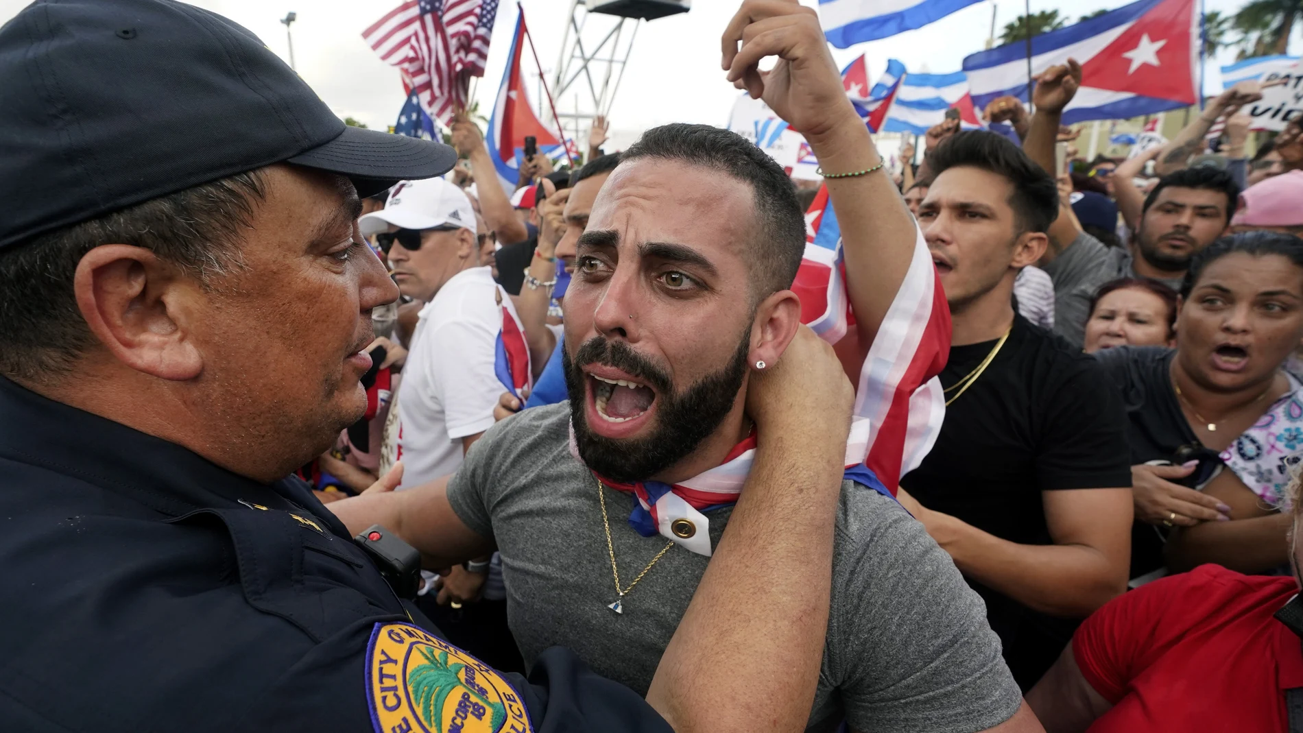 Miami Police Chief Art Acevedo, left, hugs a demonstrator, Wednesday, July 14, 2021, in Miami's Little Havana neighborhood, as people rally in support of antigovernment demonstrations in Cuba. (AP Photo/Wilfredo Lee)
