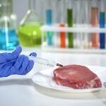 Lab worker injecting medication into meat sample, african swine flu analysis
