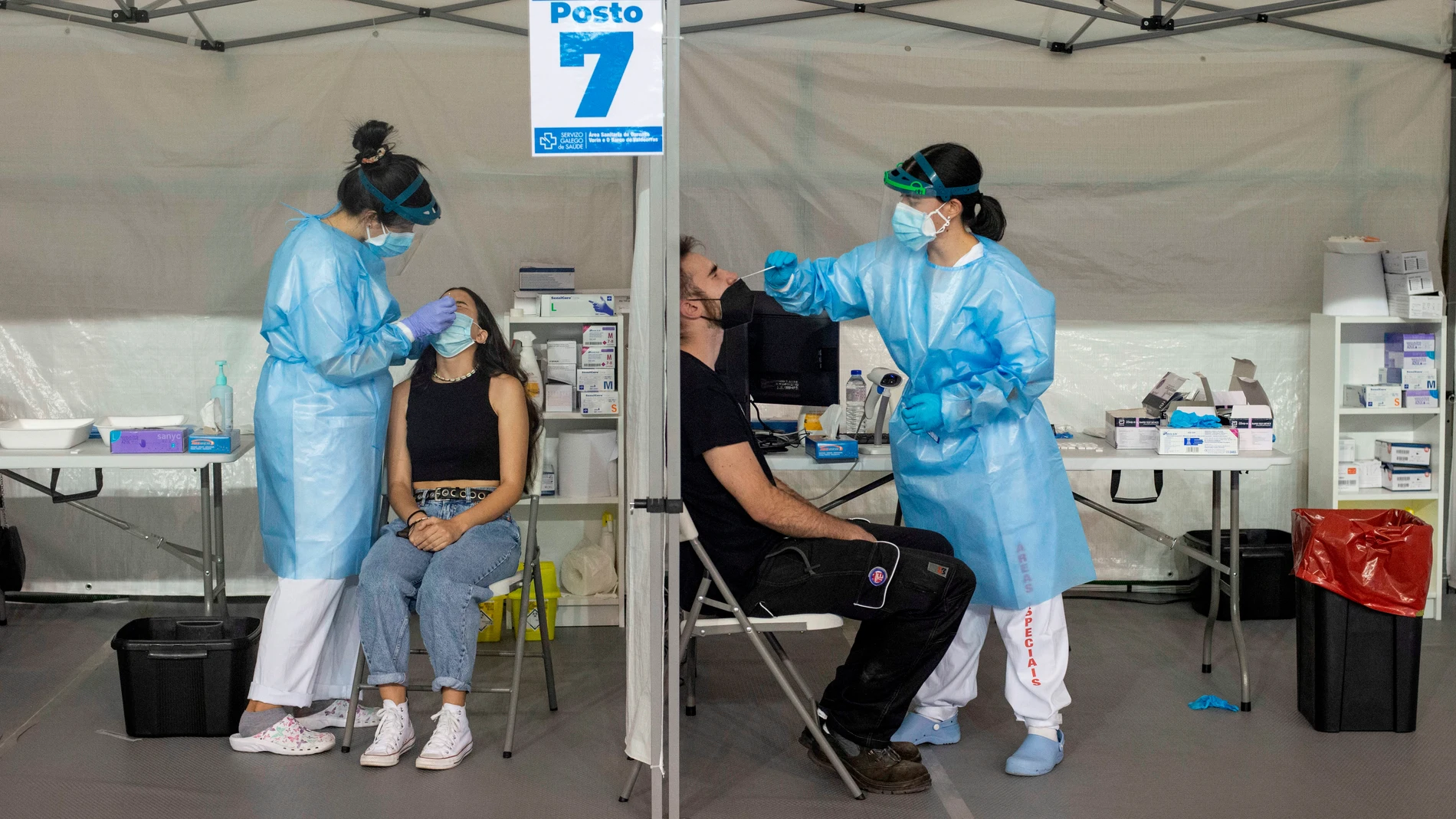 Dos trabajadoras sanitarias realizan un test de antígenos en un cribado poblacional en el pabellón de deportes Paco Paz (Orense, Galicia)