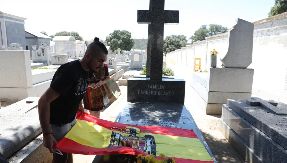 Un joven extiende una bandera preconstitucional sobre la tumba del expresidente del Gobierno Luis Carrero Blanco