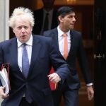 El "premier" británico, Boris Johnson, flanqueado por su ministro de Finanzas, Rishi Sunak, abandonan Dowining street