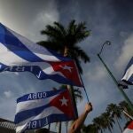 Migrantes cubanos ondean la bandera cubana en el mítico café Versailles, en Miami