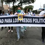 Nicaragüenses exiliados en Costa Rica sostienen una pancarta que dice &quot;Libertad para los presos políticos&quot;