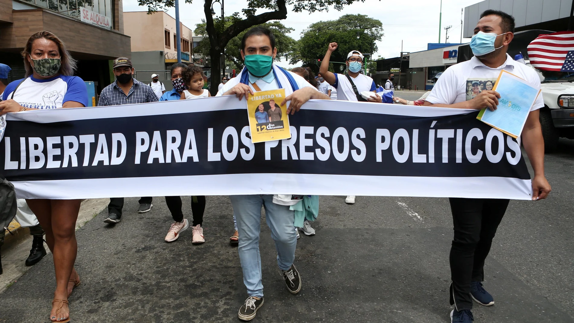 Nicaragüenses exiliados en Costa Rica sostienen una pancarta que dice "Libertad para los presos políticos"