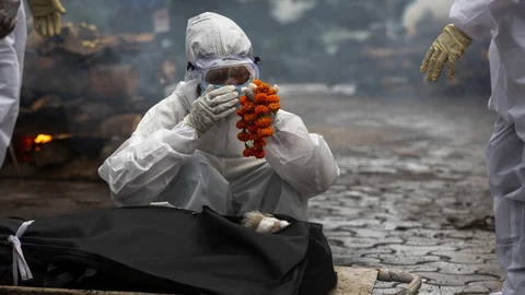 FILE - In this July 2, 2021 file photo, a relative performs last rites before the cremation of a COVID-19 victim in Gauhati, India. India's excess deaths during the pandemic could be a staggering 10 times the official COVID-19 toll, likely making it modern India's worst human tragedy, according to the most comprehensive research yet on the ravages of the virus in the south Asian country. (AP Photo/Anupam Nath, File)