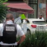 Miembros de la policía municipal y agentes periciales inspeccionan una escena del crimen donde fue asesinado el periodista mexicano Abraham Mendoza