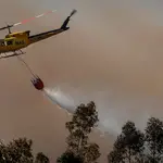 Un helicóptero del Plan Infoca trabaja en la extinción del incendio forestal de finales de julio en Villarrasa (Huelva). José Manuel Vidal / Efe