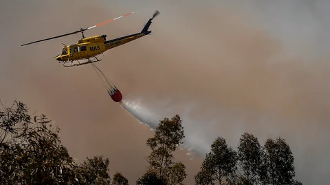 Un helicóptero del Plan Infoca trabaja en la extinción del incendio forestal de finales de julio en Villarrasa (Huelva). José Manuel Vidal / Efe