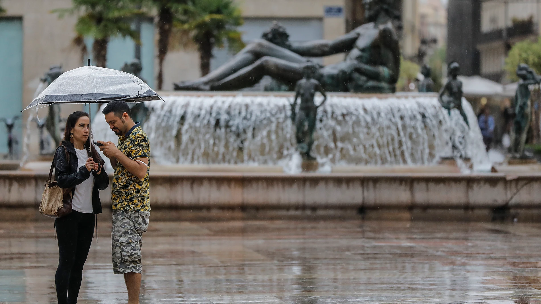 Varias personas sostienen un paraguas mientras llueve