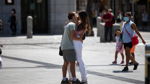 Una pareja de jóvenes en actitud cariñosa en la Puerta del Sol de Madrid