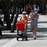 Una pareja de abuelos pasean con su nieto por Madrid