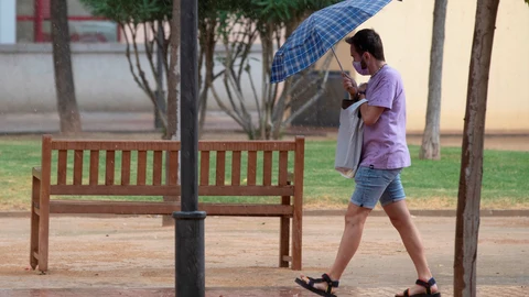 Un hombre se protege de la lluvia