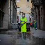 Una trabajadora limpia una vía de Barcelona