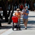 Una pareja de abuelos sacan a pasear a su nieto por Madrid Río