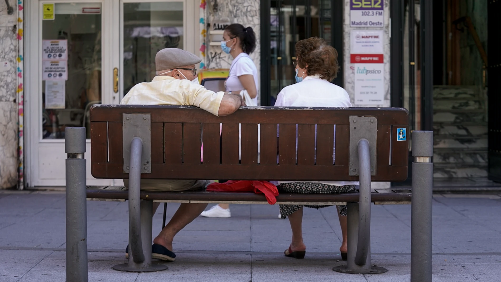 Una pareja de ancianos con mascarilla sentada en un banco, a 27 de julio de 2021, en Madrid, (España)