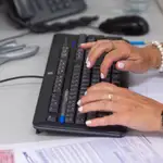 Una empleada utiliza su ordenador en su puesto de trabajo
