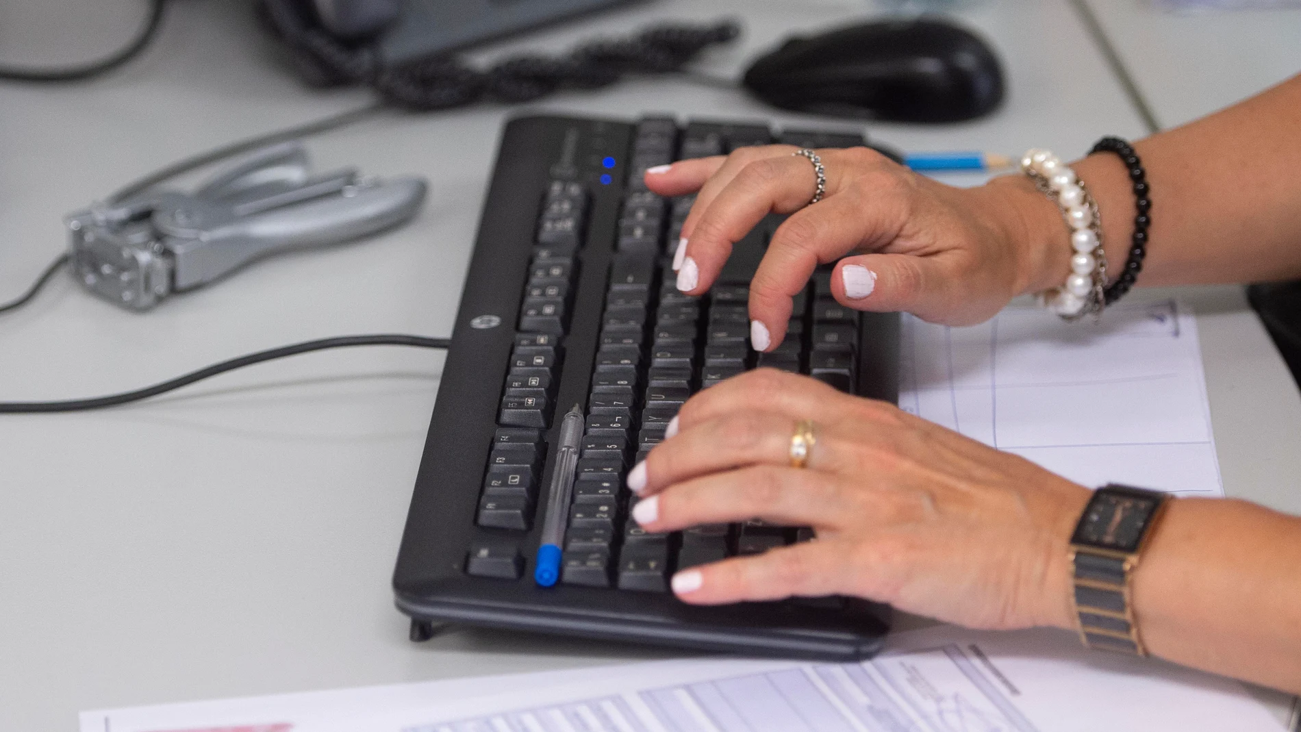 Una empleada utiliza su ordenador en su puesto de trabajo
