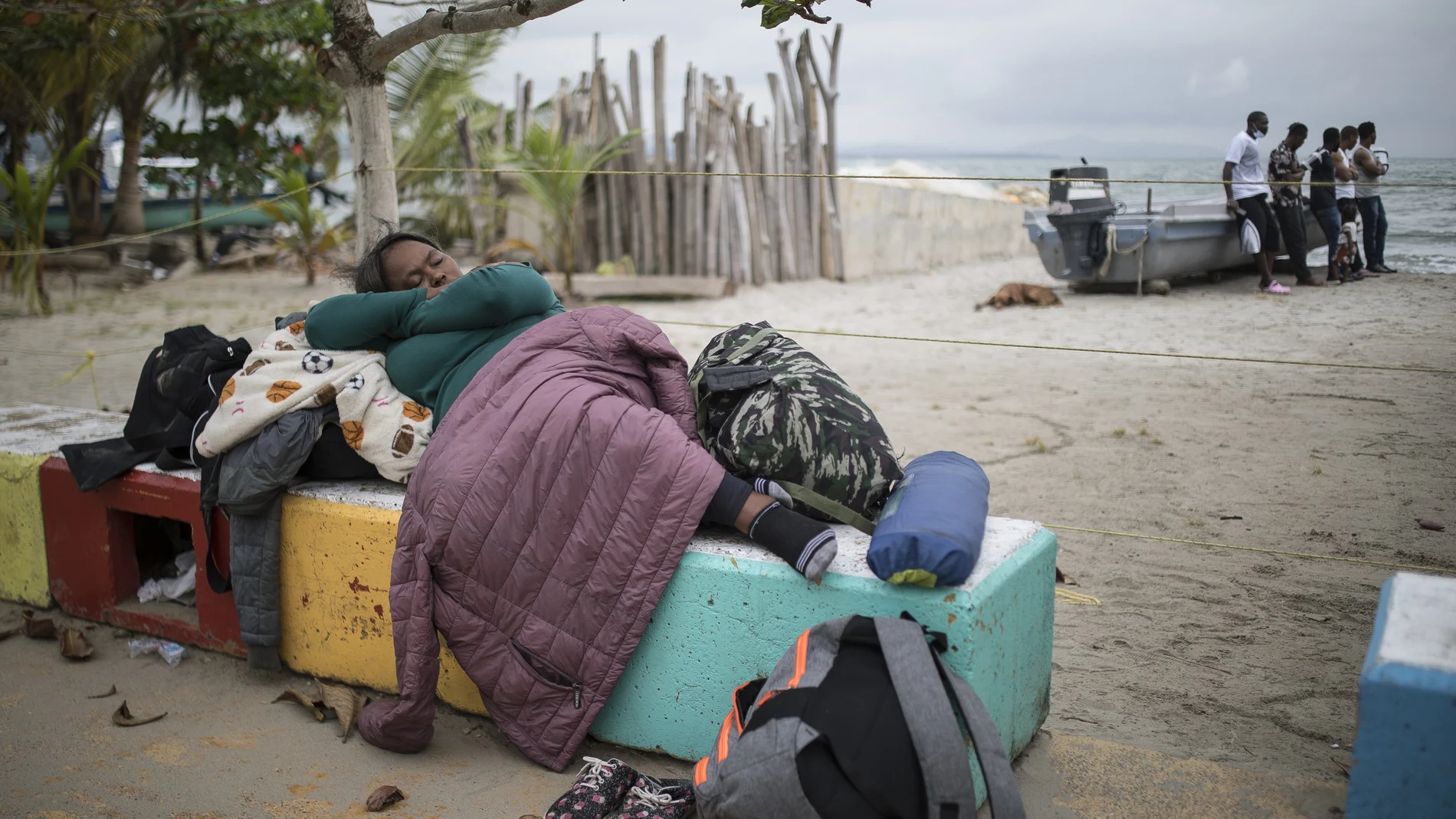 A migrant woman sleeps on a cement bench near the beach in Necocli, Colombia, Thursday, July 29, 2021. Migrants have been gathering in Necocli as they move north towards Panama on their way to the U.S. border. (AP Photo/Ivan Valencia)