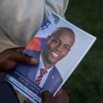 FILE PHOTO: A person holds a photo of late Haitian President Jovenel Moise, who was shot dead earlier this month, during his funeral at his family home in Cap-Haitien, Haiti, July 23, 2021. REUTERS/Ricardo Arduengo/File Photo